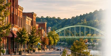 Downtown Zanesville storefronts beside the river and a green bridge